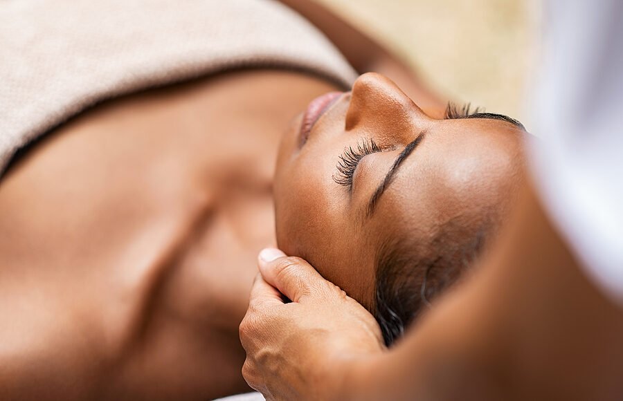 Beautiful african woman getting face massage in beauty spa. Blac